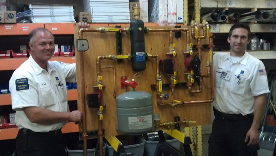 workers standing next to a boiler